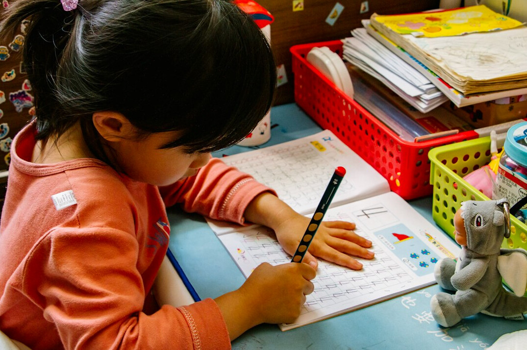Hand writing in a notebook on a desk